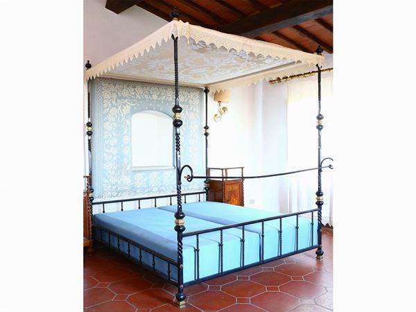 A wrougth iron canopy double bed