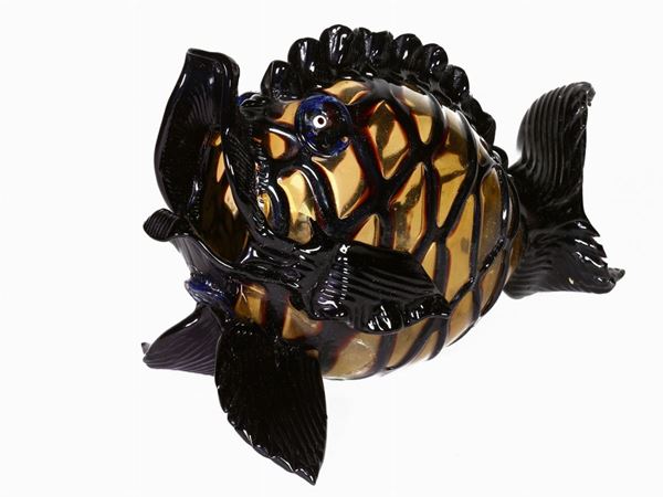 A glass amber fish with black decorations applied