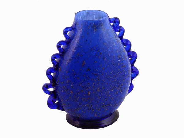 A blue glass vase with snake- shaped handles and a gold leaf decor