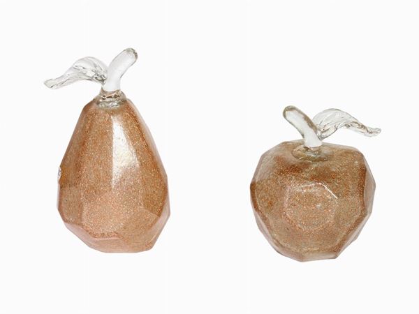 A glass apple and a pear with golden leaf