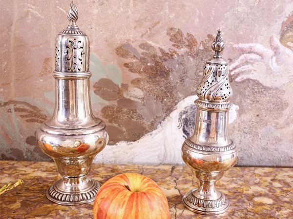 Two silver sugar shakers