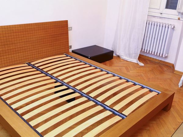 A desogn wooden double bed with a pair of night tables