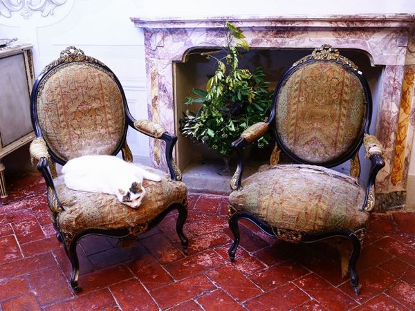 A pair of ebonized wooden armchairs