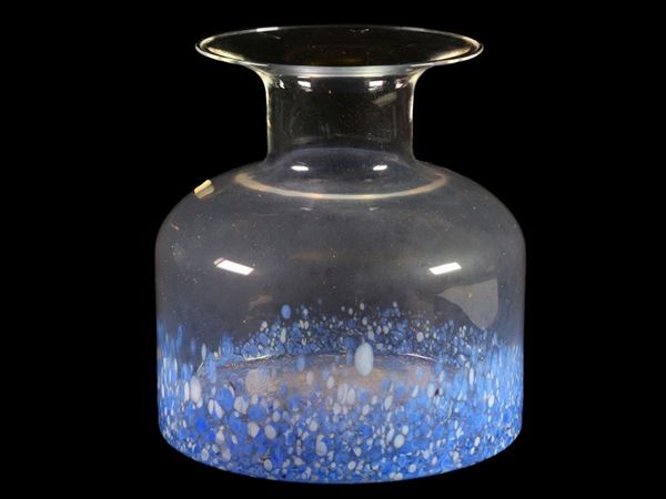 A trasparent glass vase with blue and white diffuse spots