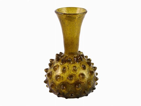 A small yellow bugnato blown glass vase