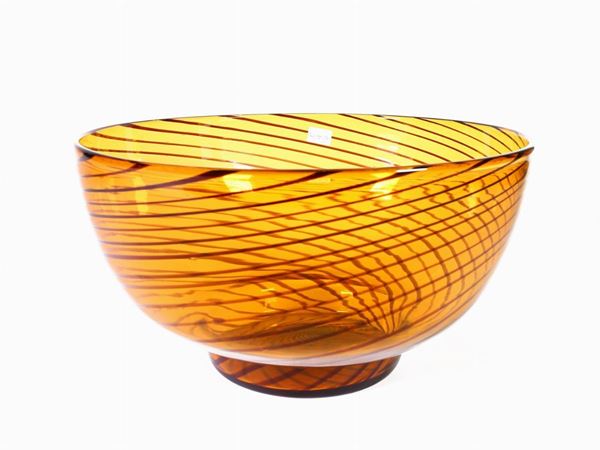 A blown orange glass bowl with brown filigree