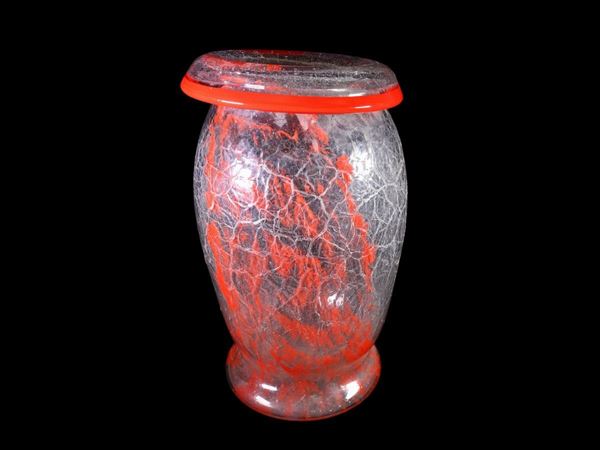 A trasparent glass vase iced surface and bright red inclusions