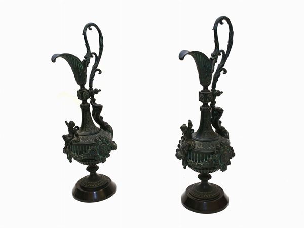 A pair of patinated metal amphoras