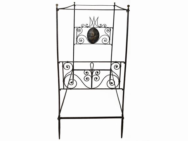 A wrought iron single canopy bed