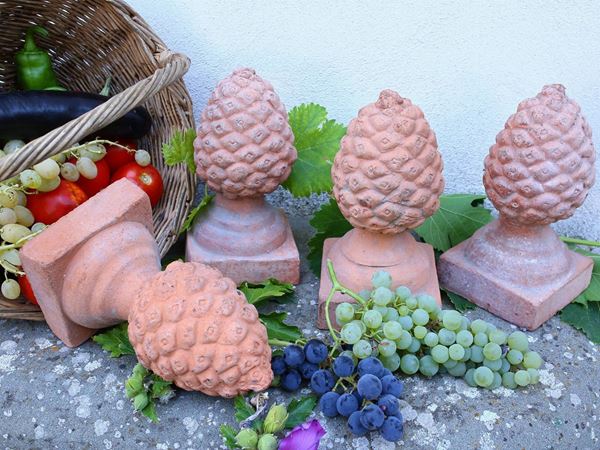 A set of four terracotta pine cones