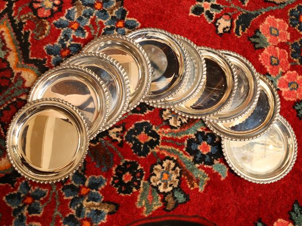 Serie di ventiquattro piattini in argento