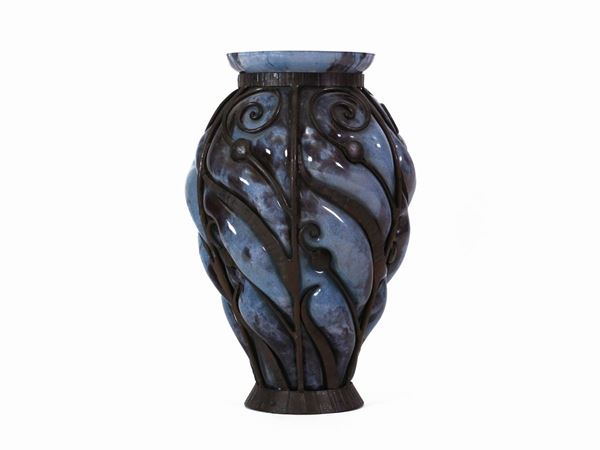 A Daum pale blue glass vase blown on the inside of an iron frame by Louis Majorelle