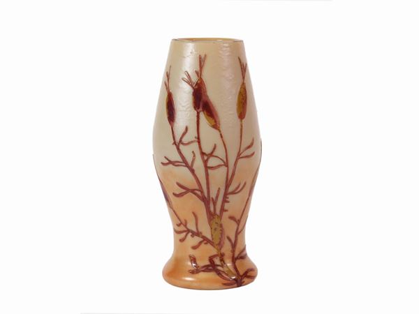 A blown orange glass vase with stylized flowers.