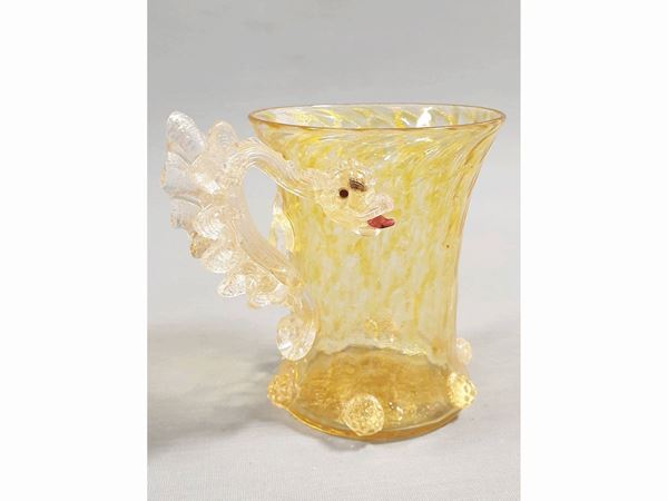 A glass amber and golden leaf glass with a dragon handle. Defects.