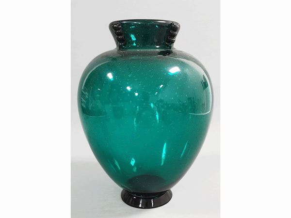 A green glass vase with bubbles and four morise glass application at the neck.
