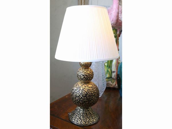 A glass craquelé black table lamp covered with golden leaf