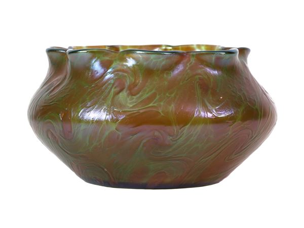 An iridescent vase with wavy mouth in shades of green and red