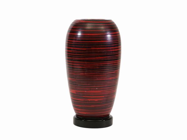 A glass vase with red and black stripes