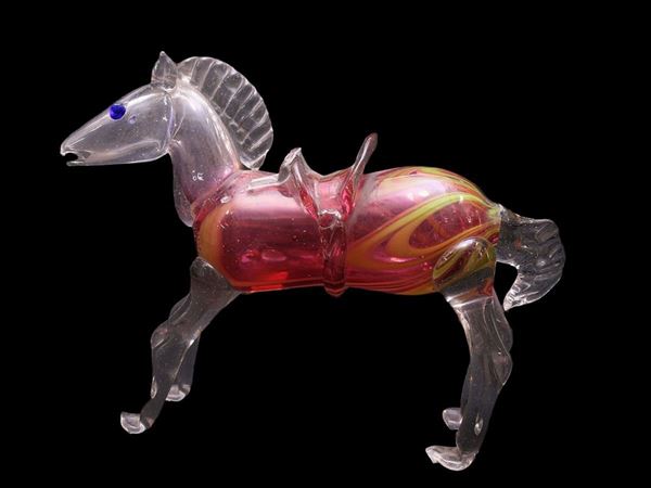 Horse in trasparent blown glass, ruby red body and hot applications. Defects.
