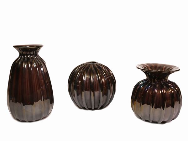 Three iridescent amethyst-coloured ribbed glass vase.