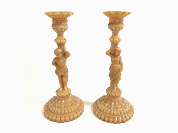 Pair of mustard-colored opaline glass candlesticks with figures.