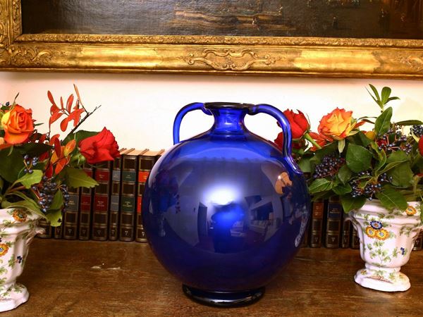 A globular vase in blue glass with hot applied handles.