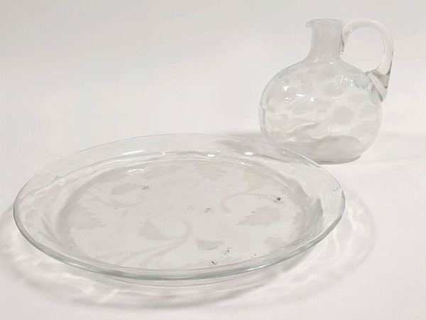 A small cup and plate in colourless glass with application of opal coloured  leaves.
