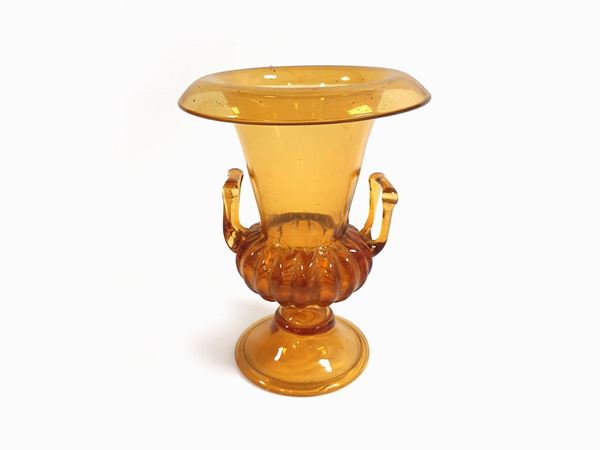 Amber-coloured glass vase with two handles on a ribbed central part and folded upper edge.