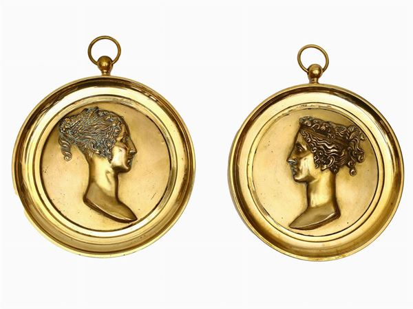 Coppia di medaglioni in ottone dorato raffiguranti profili femminili