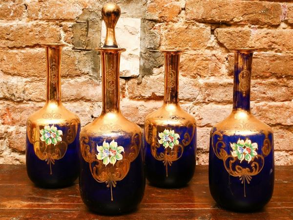 Serie di quattro bottiglie da liquore in vetro blu e oro