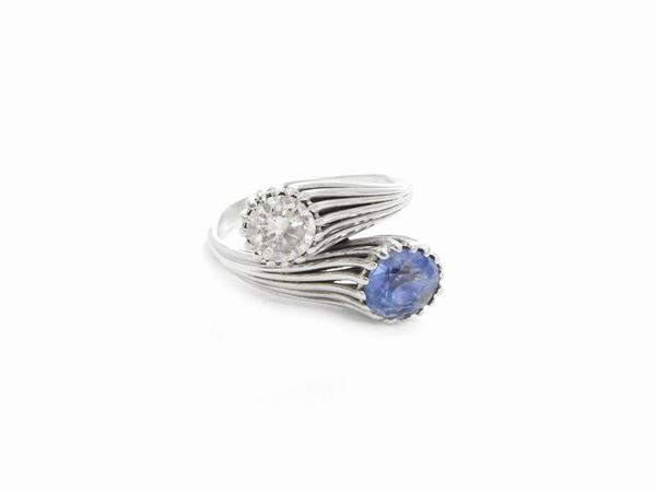 White gold contrariè ring with diamonds and sapphire