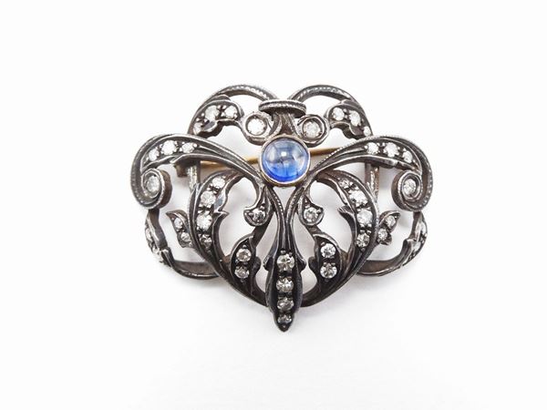 Yellow gold and silver brooch with diamonds and sapphire