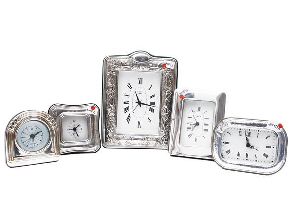 Five table clocks of various shapes and sizes