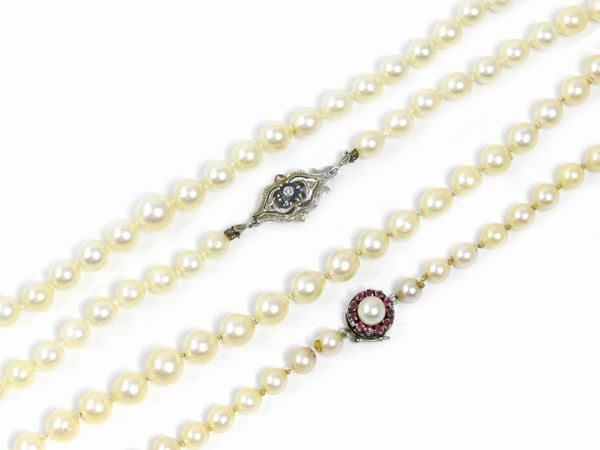 Due collane di perle coltivate con fermezze in oro bianco, diamante, rubini e zaffiri