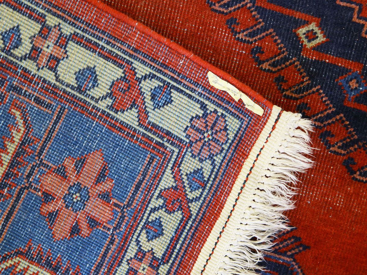 Tappeto caucasico, fondo rosso e blu con medaglioni geometrici centrali