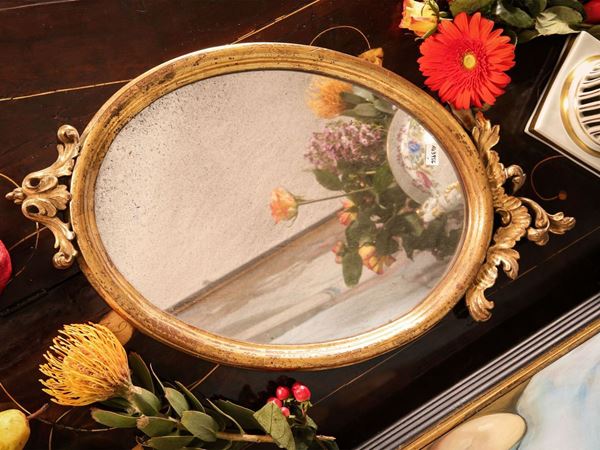 Small oval mirror in carved and gilded wood