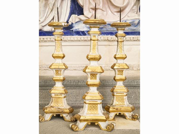 Serie di tre torciere in legno intagliato e dorato