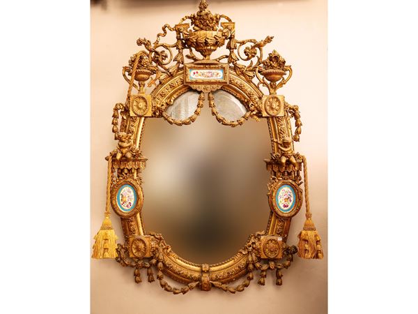 Grande specchiera di forma ovale con cornice in legno dorato e pastiglia