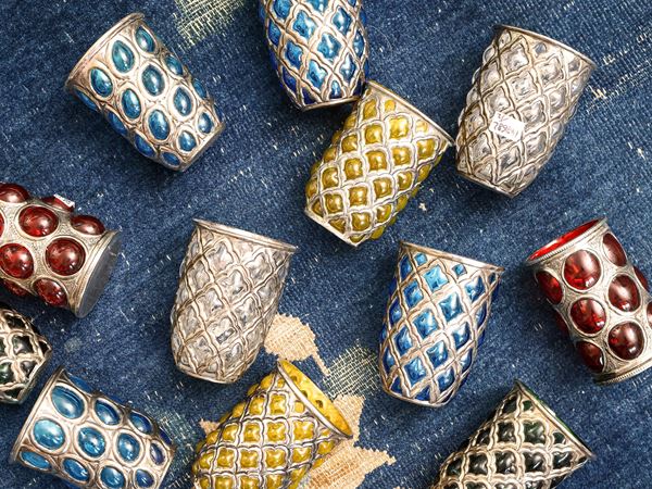 Serie di dodici bicchieri tubler in vetro colorato e metallo inciso