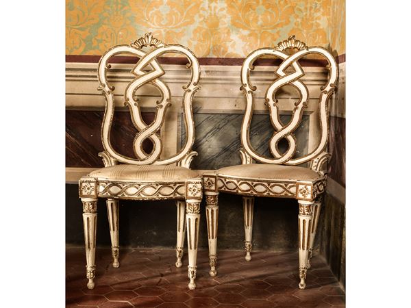Serie di quattro sedie in legno laccato bianco e dorato
