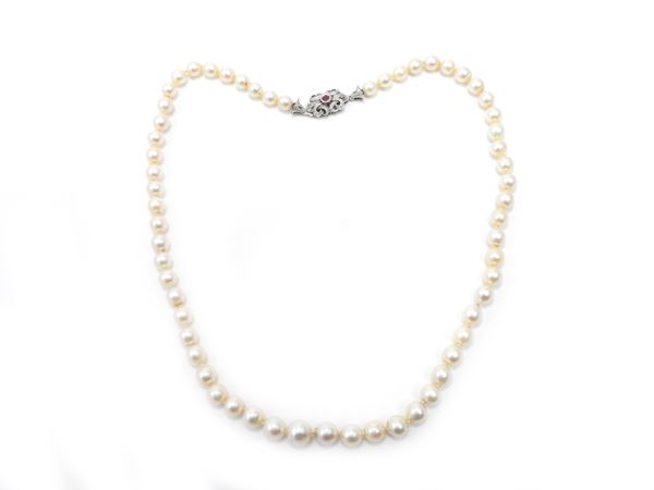 Graduated strand of cultured pearls with white gold and ruby clasp