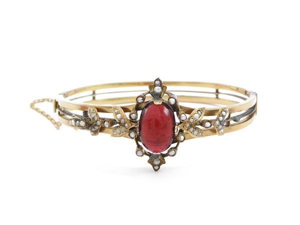 Low title gold bangle with garnet and micro-pearls