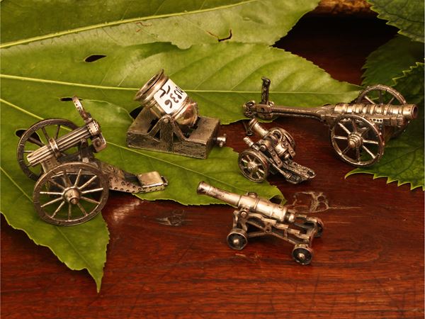 Five silver cannon miniatures