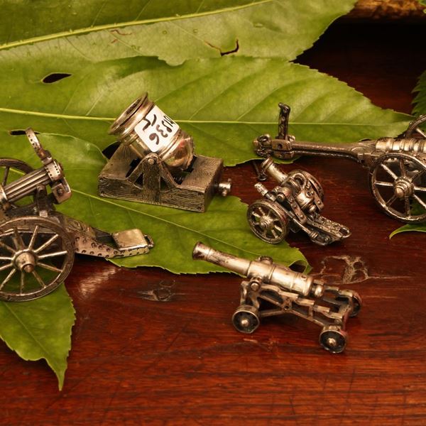 Five silver cannon miniatures