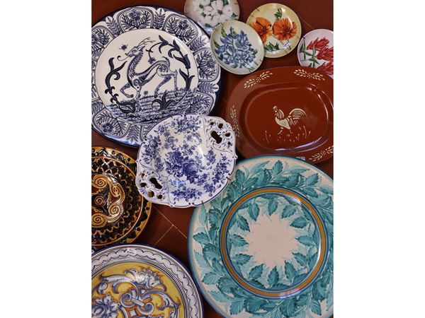 Undici piatti decorativi in terraglia, porcellana e ceramica