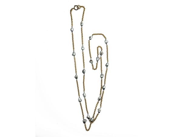 Chanel, lunga catena in metallo e perle barocche