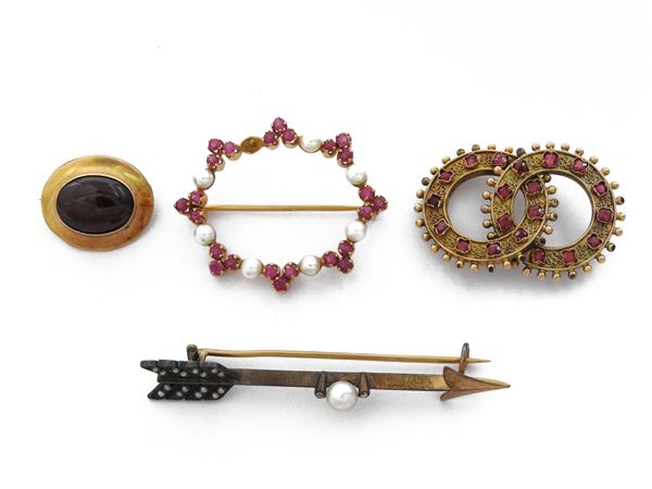 Quattro spille in oro giallo e argento con rubini, perle, granato e paste vitree