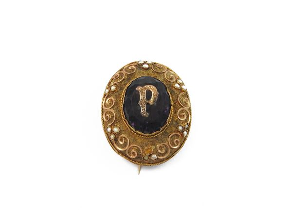 Low title gold brooch with purple glass paste and micropearls