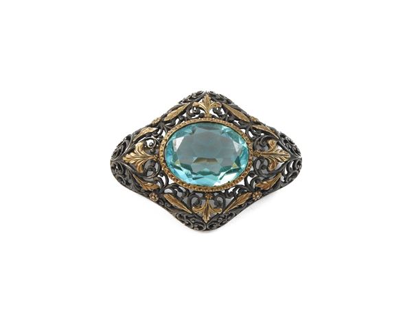 Low title gold and silver brooch with blue glass paste