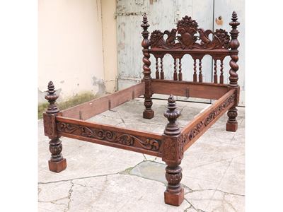 Letto monumentale in noce, con sculture zoomorfe e intagli decorativi